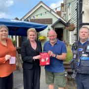 Julie Taylor and Cllr Louise McKinlay give a bleed control kit to the Black Lion pub landlord alongside PCSO Mike