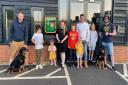 Alison Bradnick cuts the ribbon to celebrate the installation of the new defibrillator, helped by her four children Taliesin, Xander, Hermione, and Aurora and fellow residents of Walpole Meadows, Stansted