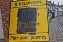 A RideLondon sign in Great Dunmow, covered with a bin liner, as the information is wrong