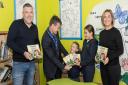 The book Grandad's Lost His Glasses is presented to Takeley Primary School headteacher Mr Cosslett, with students and Perry Sunshine and Leila Sunshine