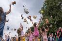 Bears and other soft toys are thrown into the air at Great Dunmow's Teddy Bears' Picnic 2021. Former mayor Cllr Emma Marcus is on the right