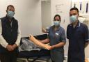 John Gardiner, practice nurse Gracy Kumar with the new arm, and deputy manager Saw Tha at Broomfield Hospital