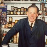 The late Michael Hitchcock of Great Bardfield, seen here behind the counter in the village shop Hitchcocks