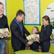 The book Grandad's Lost His Glasses is presented to Takeley Primary School headteacher Mr Cosslett, with students and Perry Sunshine and Leila Sunshine