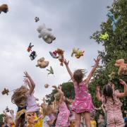 Bears and other soft toys are thrown into the air at Great Dunmow's Teddy Bears' Picnic 2021. Former mayor Cllr Emma Marcus is on the right